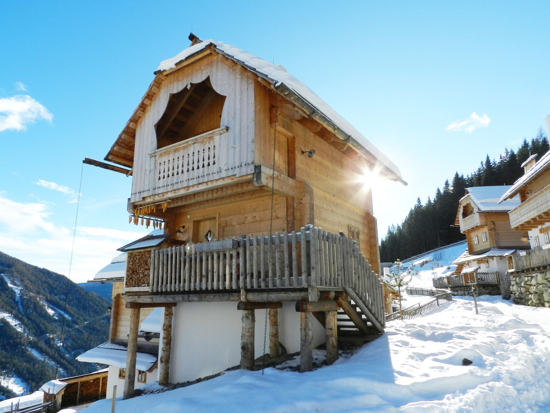 Houten chalet in een zonnig besneeuwd bergdorp