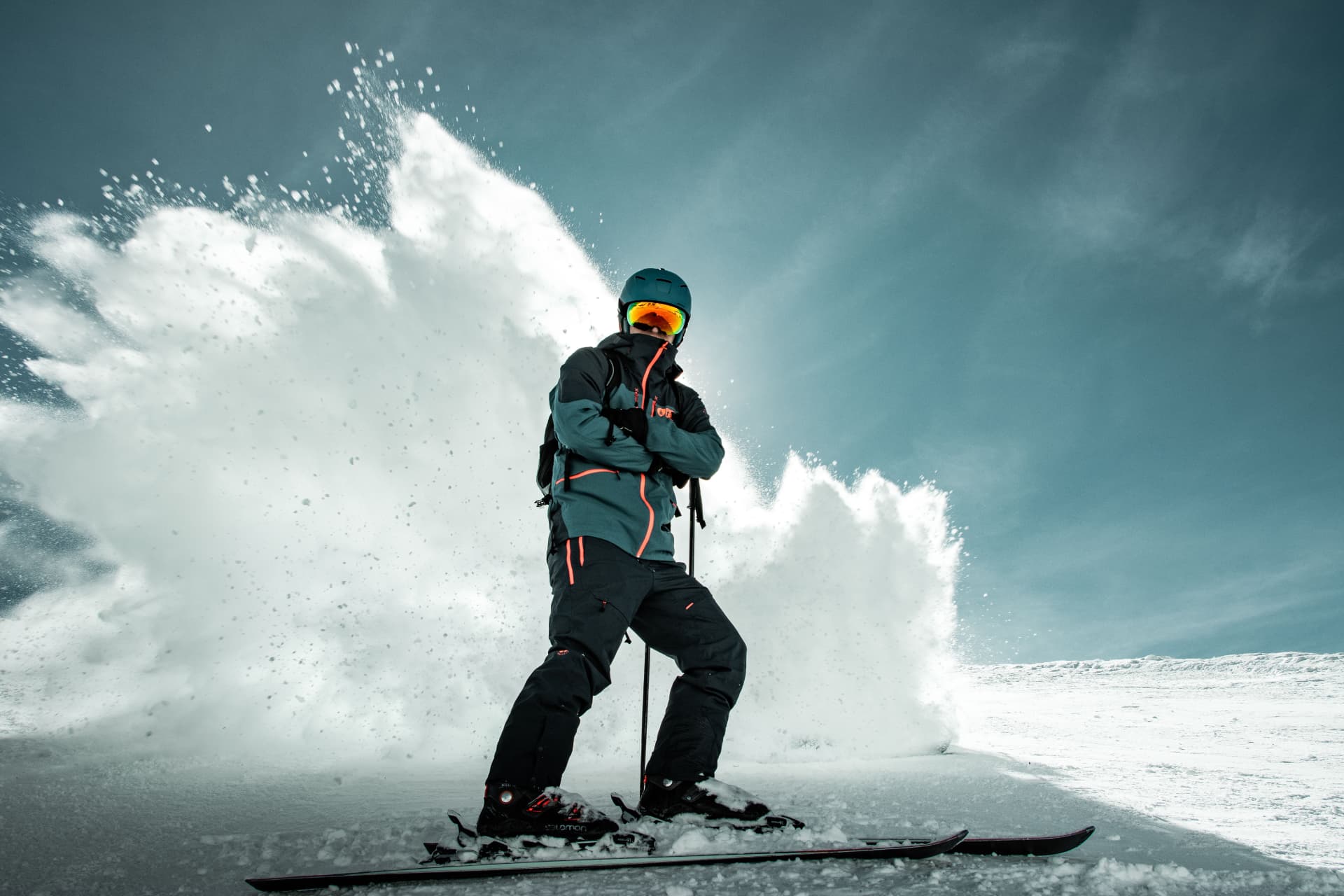 Skiër met opstuivende sneeuw op een bergpiste